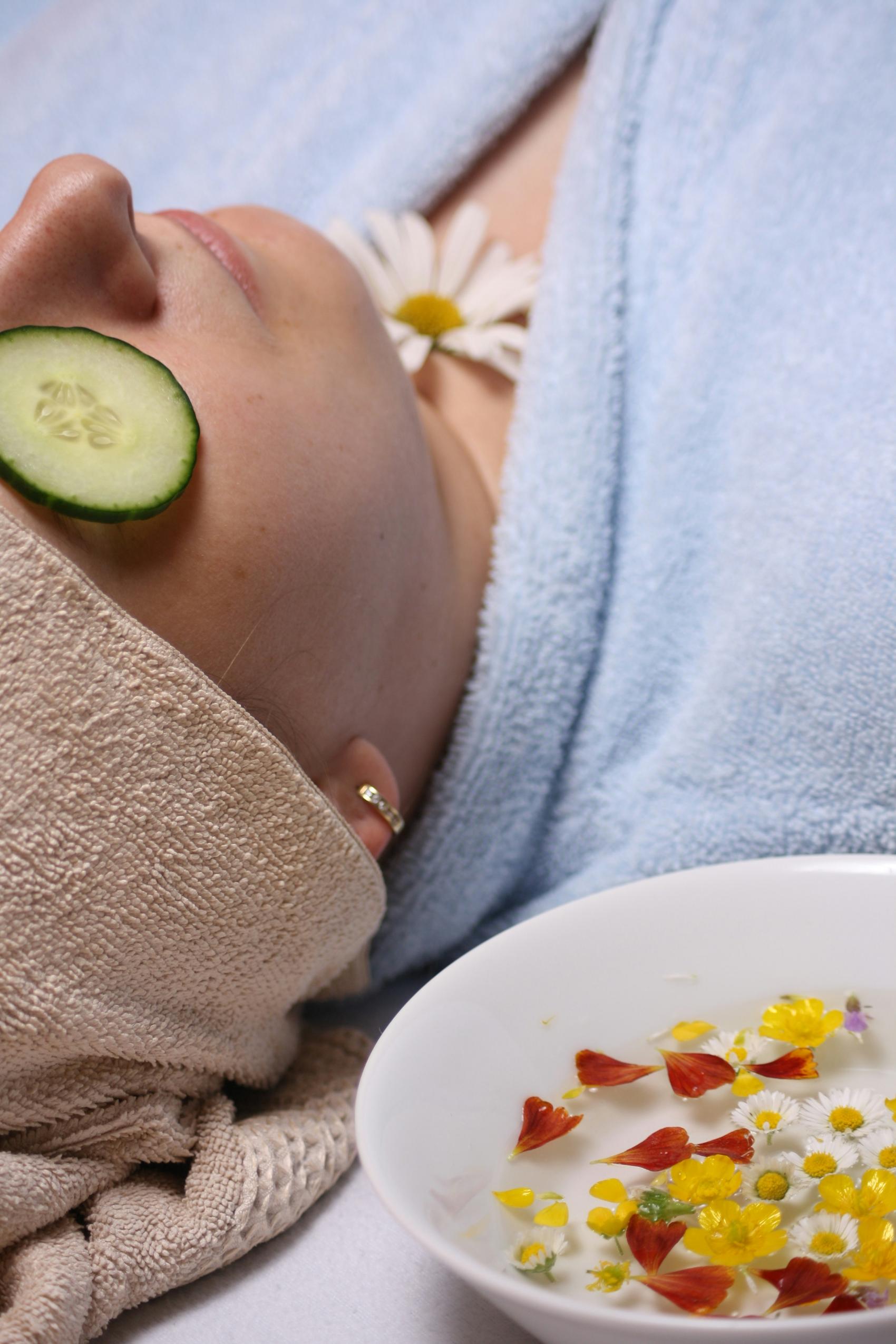 Relaxing with cucumber on face, flowers.